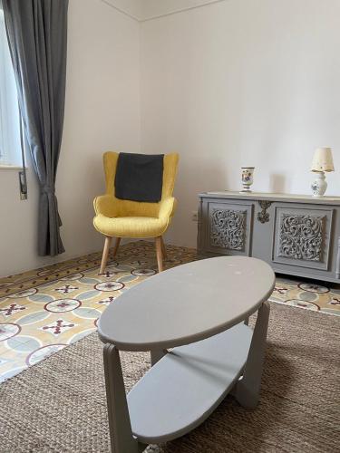 a living room with a table and a chair at Casinhas Alegria in São Marcos do Campo