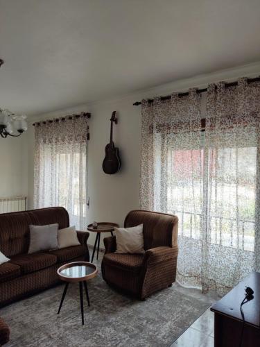 a living room with two couches and a guitar at Casa sossegada na Batalha in Batalha