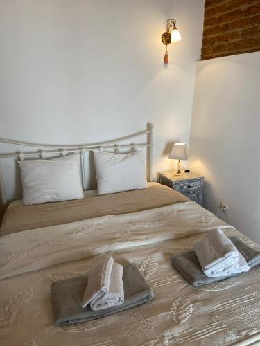 a bedroom with a bed with towels on it at Casinhas Alegria in São Marcos do Campo