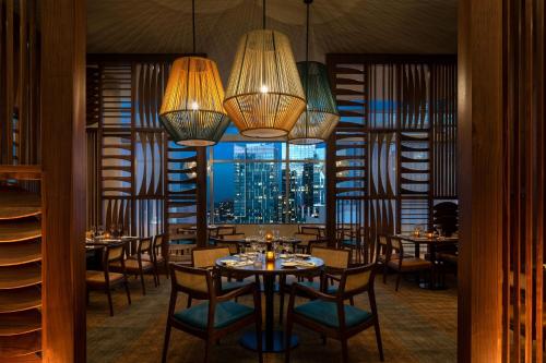 a dining room with tables and chairs and a window at JW Marriott Los Angeles L.A. LIVE in Los Angeles