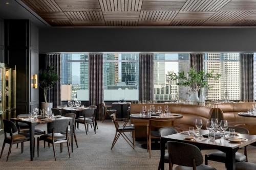 a restaurant with tables and chairs and large windows at JW Marriott Los Angeles L.A. LIVE in Los Angeles