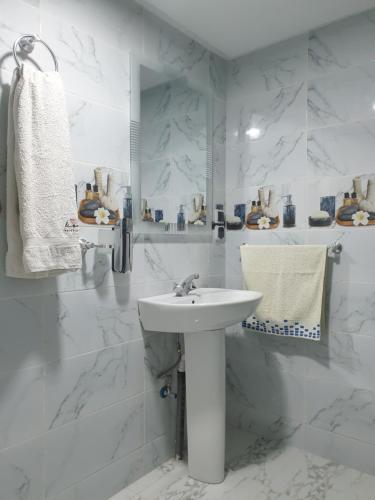 uma casa de banho branca com um lavatório e um espelho em White House em Azrou