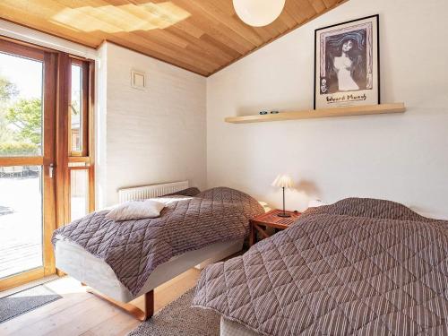 two beds in a room with a window at 8 person holiday home in Skagen in Skagen