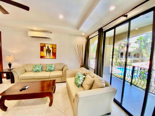 a living room with two couches and a table at Monte Carlo Luxury Condominiums in Jacó