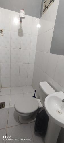 Baño blanco con aseo y lavamanos en Casa Hotel Vida Caranavi, La Paz, en Caranavi