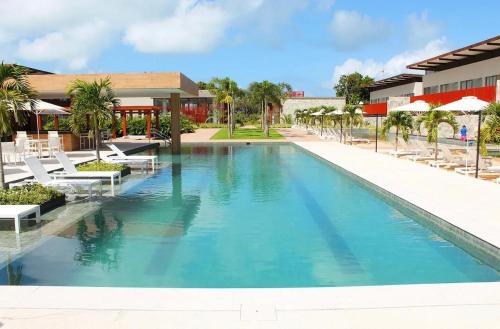 a large swimming pool with chairs and a resort at ILE de Pipa Resort Quarto Superior Frente Piscina in Pipa