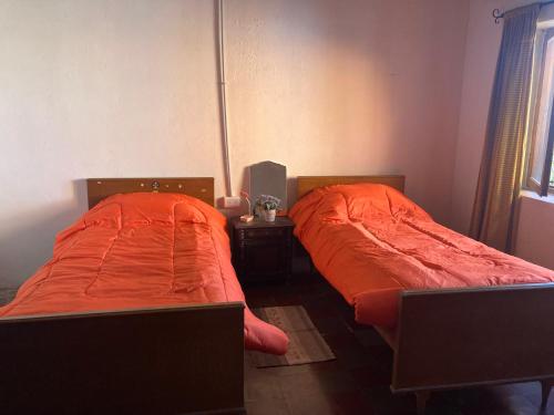two beds sitting next to each other in a room at Casa de campo rústica in Tandil