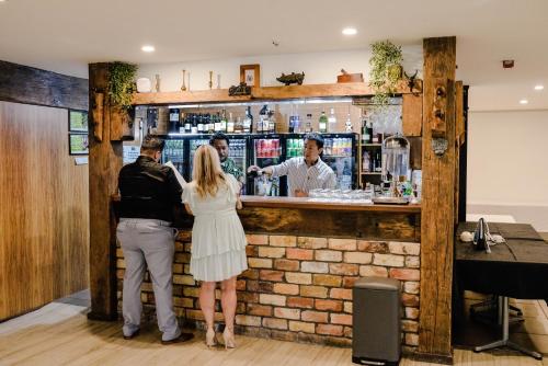 a group of people standing at a bar at Northridge Golf Resort in Orewa