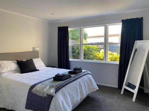 a bedroom with a bed and a large window at Lovely Newly Renovated Home in Hamilton