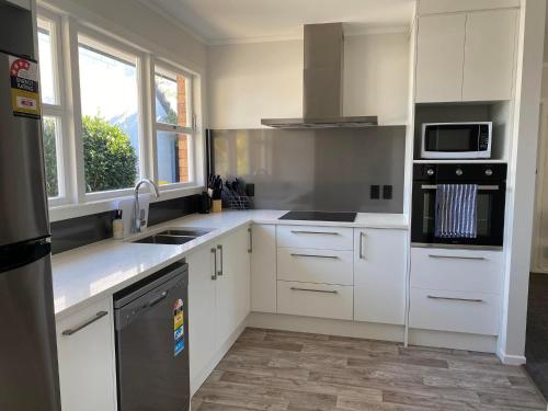 a kitchen with white cabinets and a stove top oven at Lovely Newly Renovated Home in Hamilton