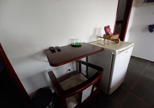 a small kitchen with a small table and a small refrigerator at Pousada do Xerife in Caconde