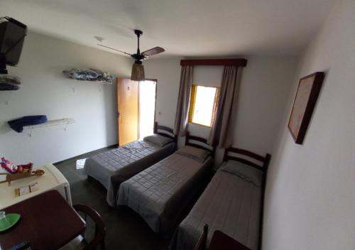 a living room with two beds and a window at Pousada do Xerife in Caconde