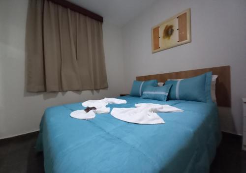 a blue bed with two white towels on it at Pousada do Xerife in Caconde