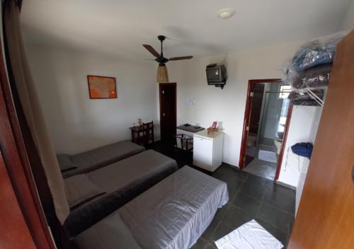 a living room with a couch and a ceiling fan at Pousada do Xerife in Caconde