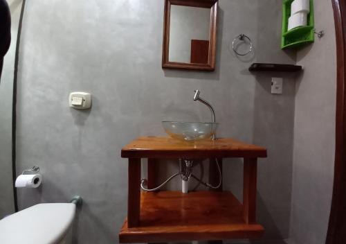 a bathroom with a bowl sink on a wooden table at Pousada do Xerife in Caconde