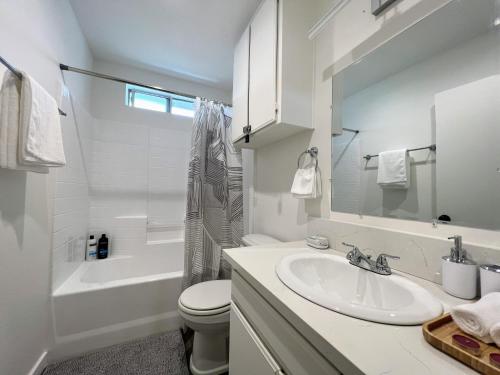 Un baño blanco con lavabo e inodoro. en Hollywood Purple Habitat, en Los Ángeles