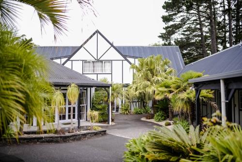 a large white building with palm trees in front of it at Northridge Golf Resort in Orewa