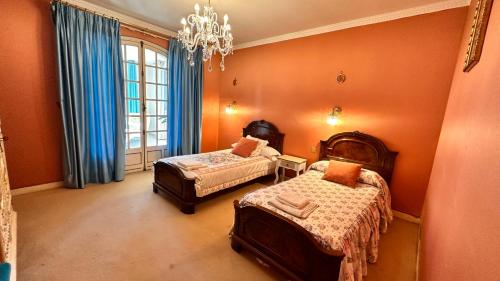 1 Schlafzimmer mit 2 Betten und einem Kronleuchter in der Unterkunft VILLA DAVID in Horta