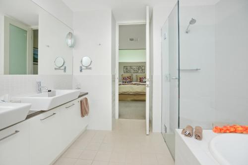 a white bathroom with two sinks and a shower at SEABREEZE at Victor Harbor in Victor Harbor