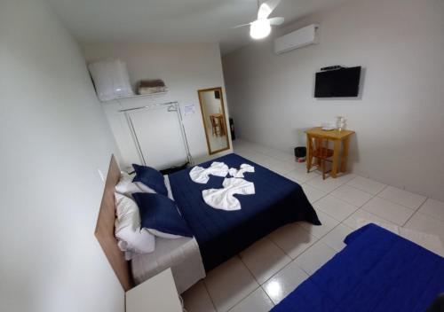 a bedroom with a blue bed with towels on it at Pousada do Xerife in Caconde