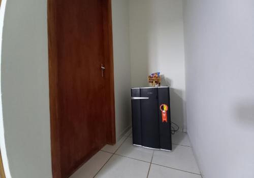 a black refrigerator in a room next to a door at Pousada do Xerife in Caconde