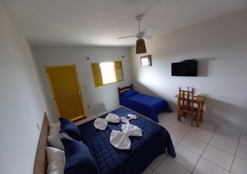 a bedroom with a blue bed with towels on it at Pousada do Xerife in Caconde