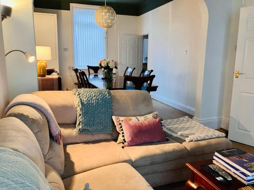 a living room with a couch and a table at Romford Cottage - Close to Centre, Hospital CrownWorks Studio Nissan and Stadium of Light in Sunderland