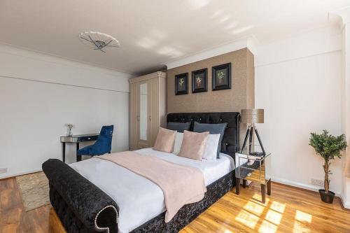 - une chambre avec un grand lit et un bureau dans l'établissement Beautiful Two Bedroom Apartment Nearby Hyde Park, à Londres
