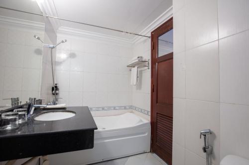 a bathroom with a sink and a bath tub at Blau Hotel in Hanoi