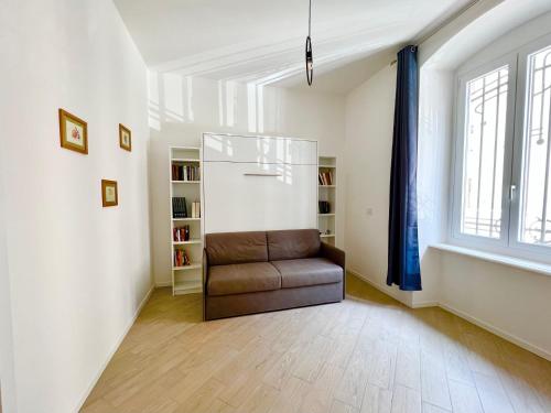 uma sala de estar com uma cadeira de couro e uma janela em Casa Genova 1/2/3 em Turim
