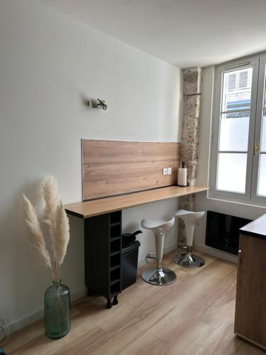 una oficina con escritorio y dos taburetes en una habitación en Magnifique Studio - Hypercentre ancien pieton Orléans - Wifi - Accès autonome, en Orléans