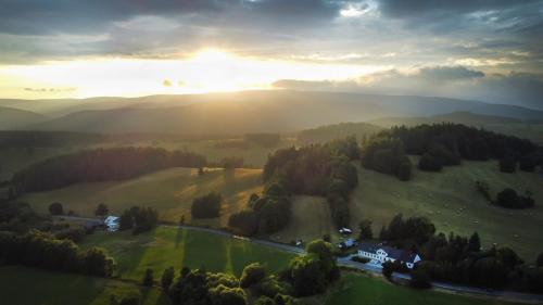 a house on a hill with the sunset in the background at Ubytování u Nováků in Malá Morávka