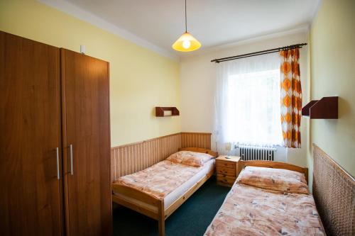 a small bedroom with two beds and a window at Ubytování u Nováků in Malá Morávka