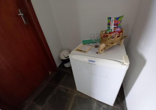 a white refrigerator with a basket on top of it at Pousada do Xerife in Caconde