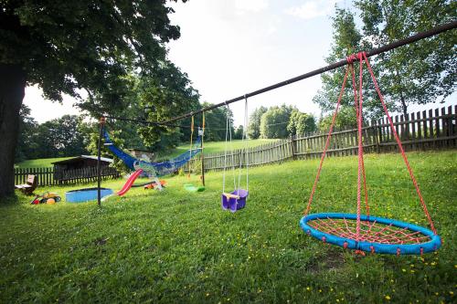a playground with swings in a yard at Ubytování u Nováků in Malá Morávka
