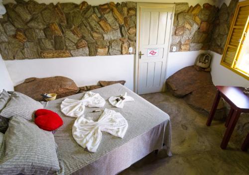 a bedroom with a bed with towels on it at Pousada do Xerife in Caconde