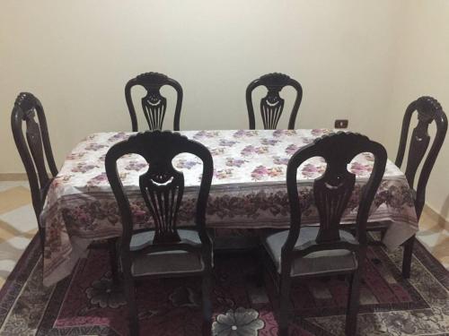 mesa de comedor con 2 sillas y mesa con mantel en عقار السلام, en Kafr Rāshid