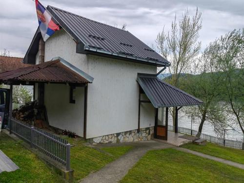 ein Haus mit einem Dach mit einer Flagge darauf in der Unterkunft Vikendica Drina in Ljubovija