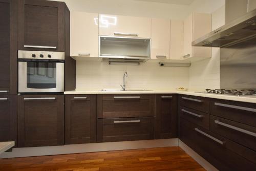 a kitchen with brown cabinets and a stove top oven at Villafranca Relaxing apartment in Villafranca Padovana
