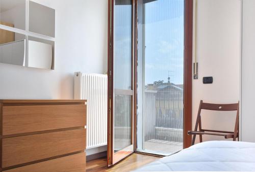 a bedroom with a bed and a desk and a window at Villafranca Relaxing apartment in Villafranca Padovana