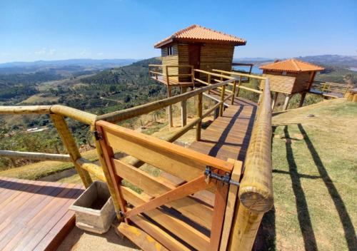 a wooden deck with a lookout tower on top of a hill at Pousada do Xerife in Caconde