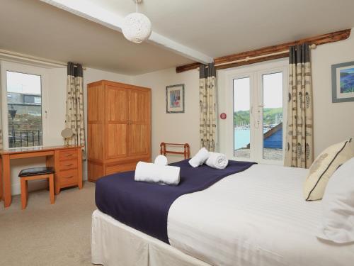 a bedroom with a large bed with a desk and windows at Ferry View in Dartmouth