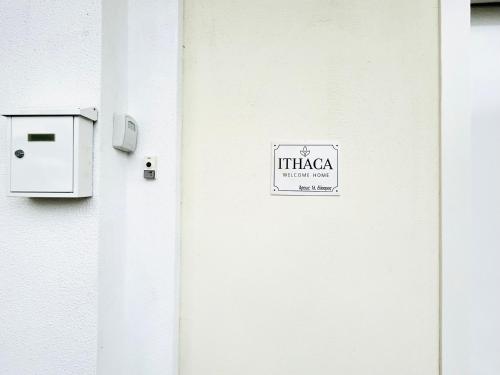 a white door with a sign on the side of a building at Ithaca: Διαμέρισμα με αυτόνομη είσοδο. in Thessaloniki