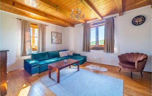 a living room with a green couch and a table at Stunning Home In Bosiljevo With 2 Bedrooms, Wifi And Outdoor Swimming Pool in Bosiljevo
