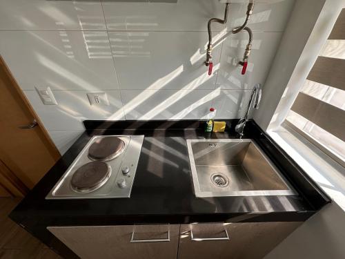 a small kitchen with a sink and a stove at TinyApartments - estudio pleno centro Concepción in Concepción