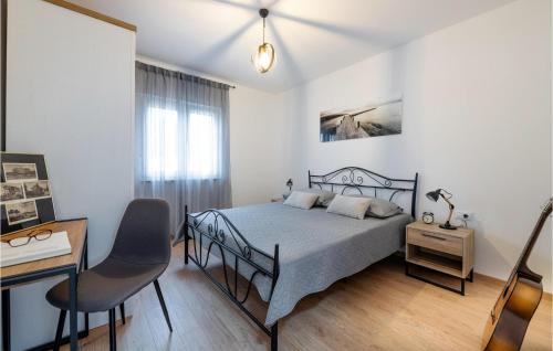 1 dormitorio con cama, escritorio y silla en Lovely Home In Radeki Glavica With House A Panoramic View, en Loborika