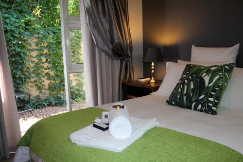 a bedroom with a bed with a towel and a window at Olive Tree B&B in Upington