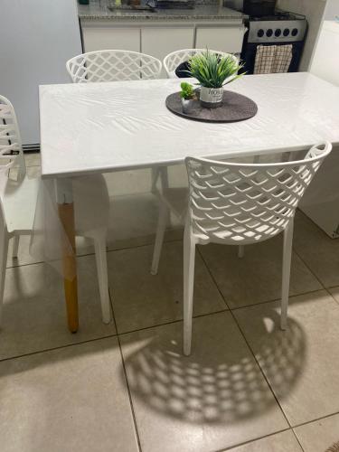 a white table and chairs with a potted plant on it at Monoambiente amplió in Rosario