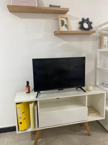 a white entertainment center with a flat screen tv on it at Monoambiente amplió in Rosario