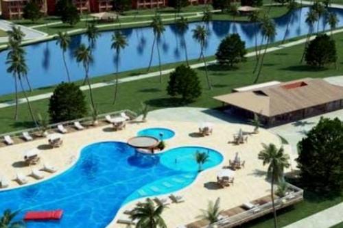 an overhead view of a large swimming pool with palm trees at Apartamento no Condomínio Vila das Águas in Estância